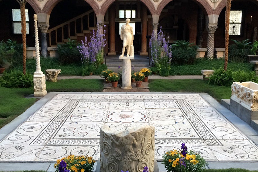 Flowers and green grass decorate the Gardner Museum's courtyard