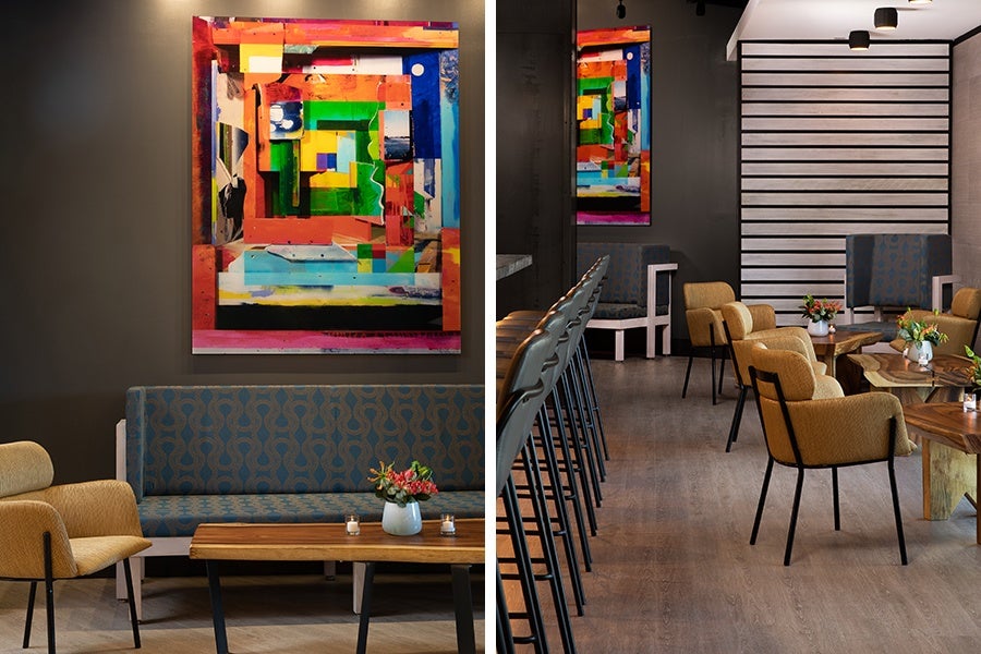 The "living room" at Alcove has comfortable sofas and low tables, plus colorful art by Quinn Gorbutt