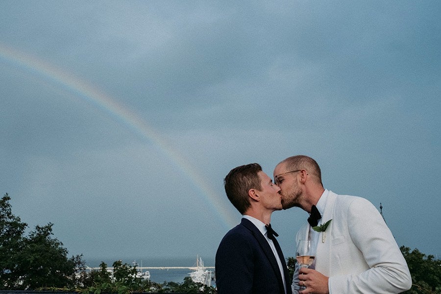 couple kisses under a rainbow at Provincetown wedding