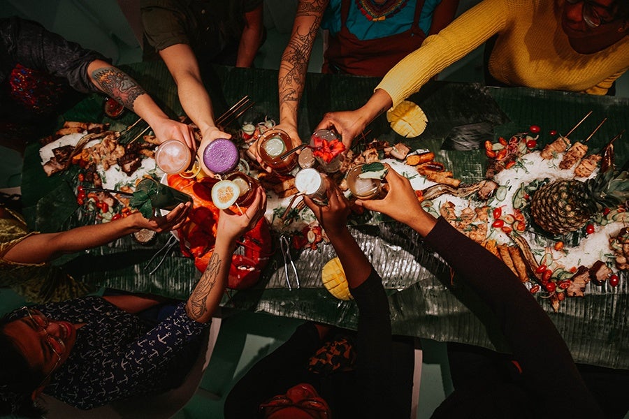 People saying "cheers" around a table at Tanam in Somerville