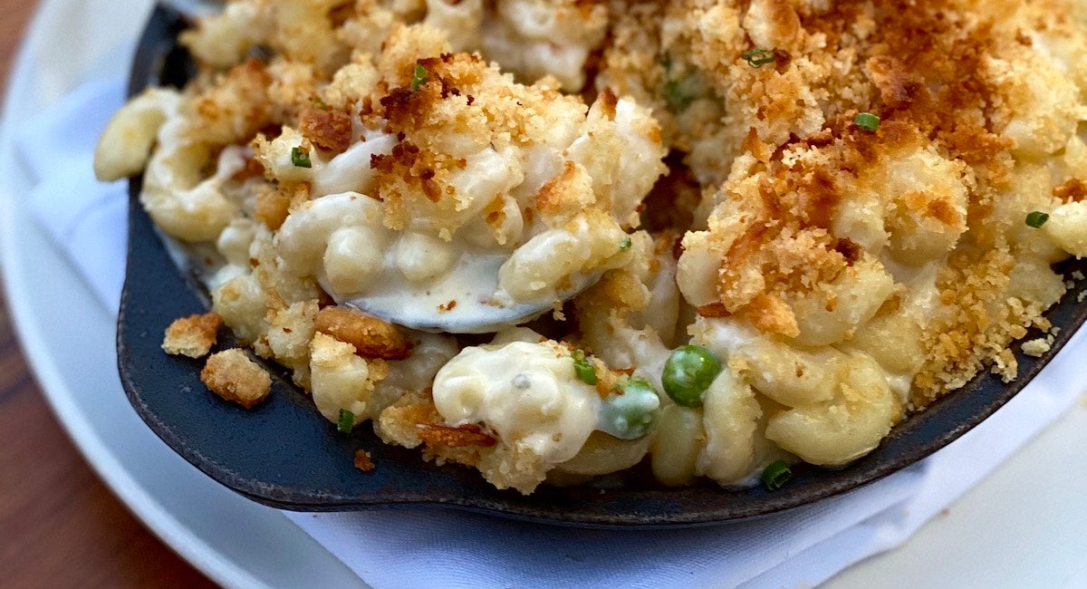 Cavatappi is smothered in cheese, bread crumbs, and herbs, served in a cast-iron skillet.