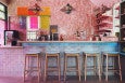 A well-lit bar features shimmery pink walls and a well-lit ambiance.