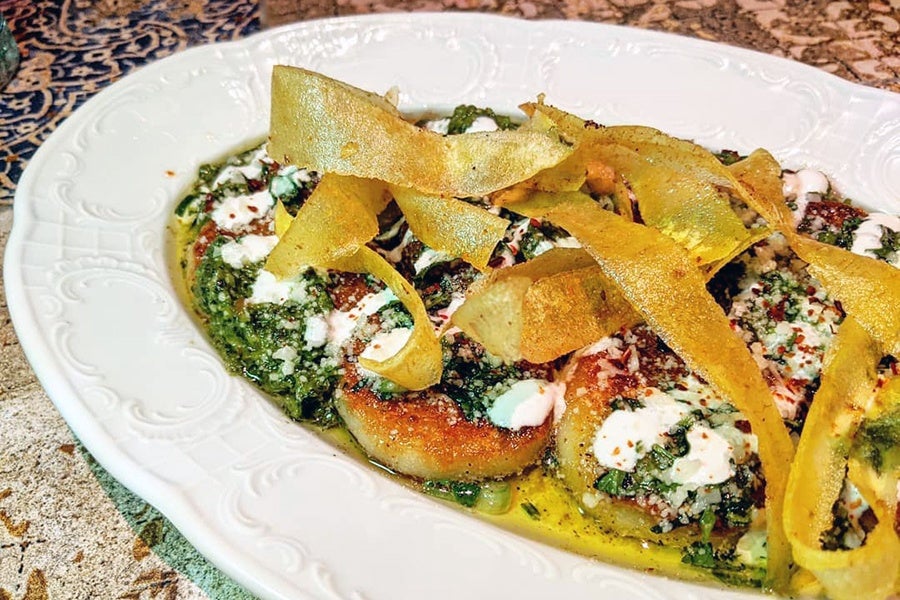 Big pan-seared gnocchi are topped with a green pesto and crispy dough strips.