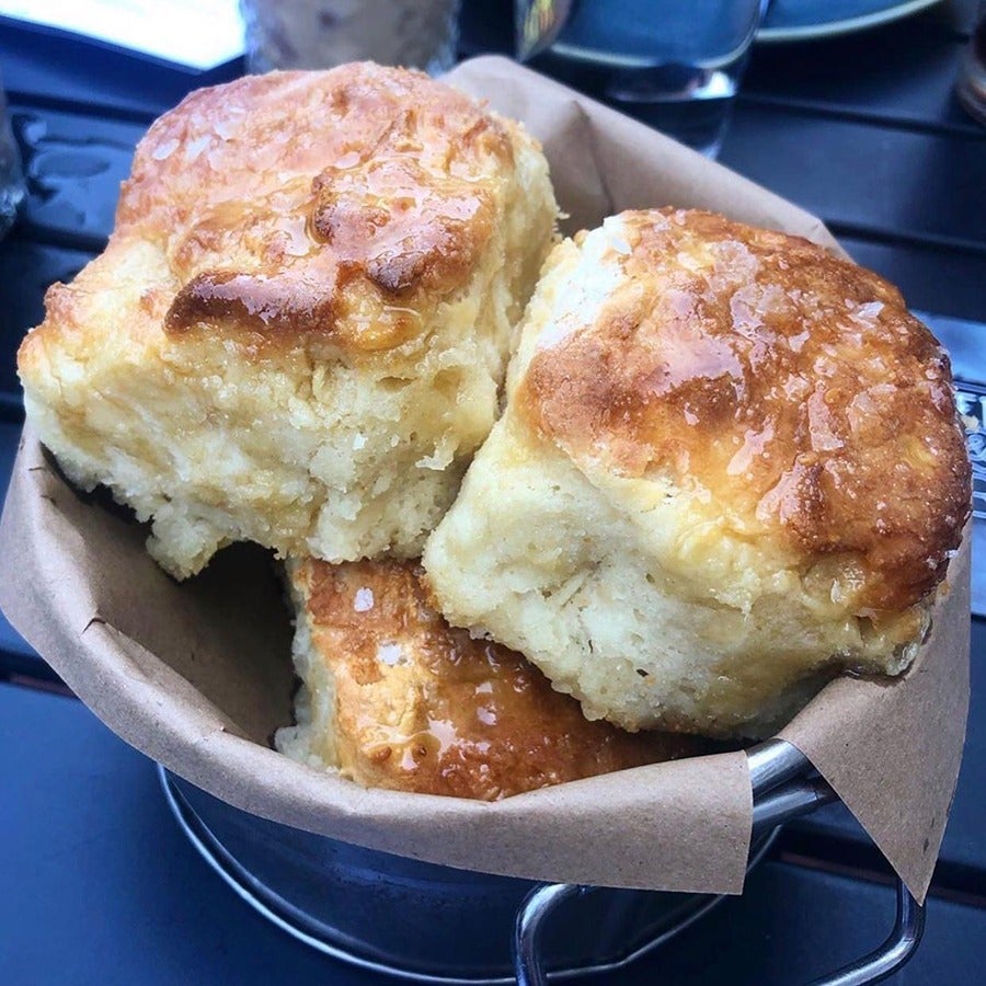 A basket of fluffy, golden-brown buttermilk biscuits.