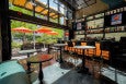 A small bar is opened up wide to an outside patio decorated with orange umbrellas.
