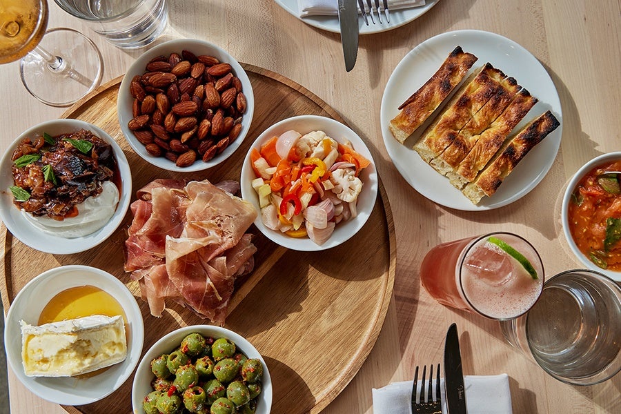 Overhead view of almonds, cured meat, giardiniera, olives, and other Mediterranean snacks.