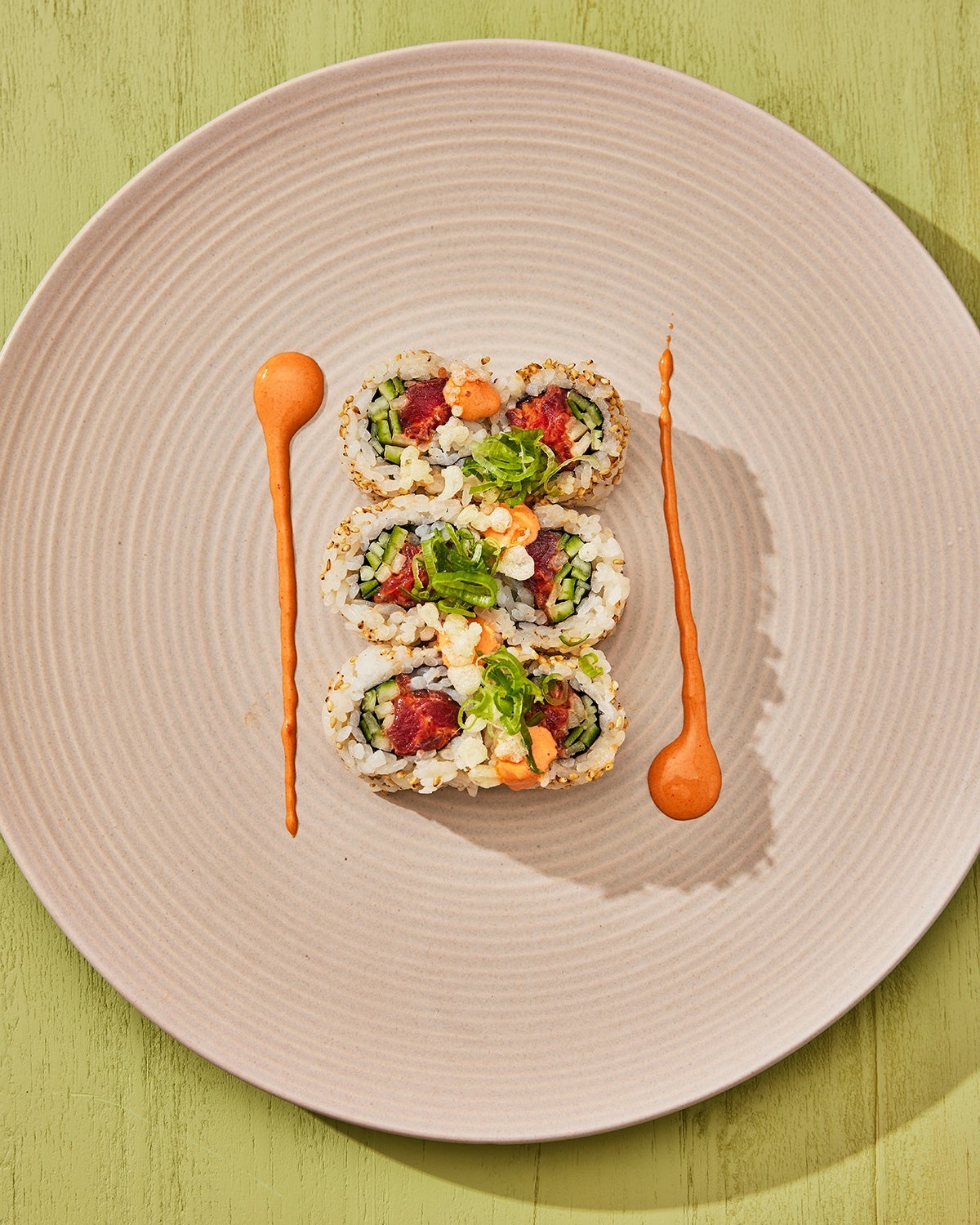 Uni’s spicy tuna makimono roll plated artfully, with two dollop streaks of thai bird chili mayo.