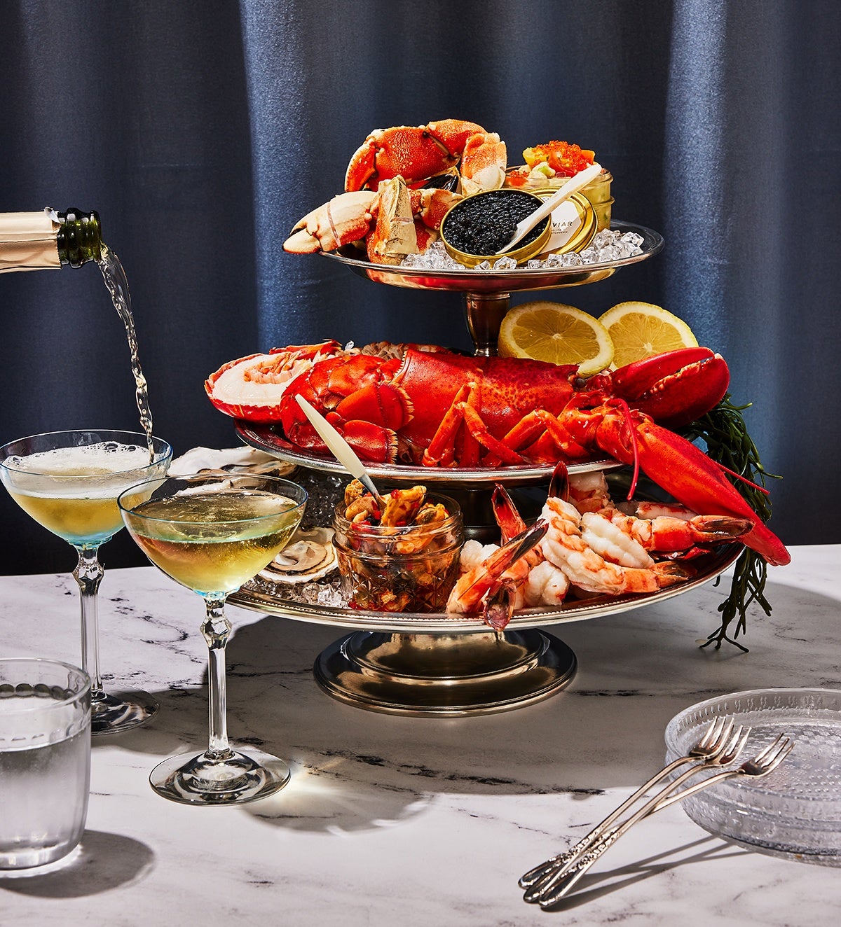 A three-tier shellfish tower from Row 34 with Jonah crab claws, Maine half lobsters, shrimp cocktail, and Island Creek caviar.