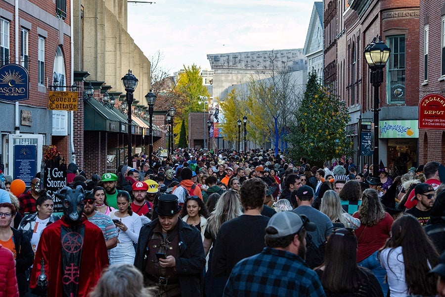 Crowds of revelers, many in costume, pack a downtown street in Salem, Massachusetts, on Halloween.