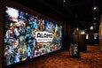 One hallway of a movie theatre is decorated with colorful signage advertising Alamo Drafthouse.