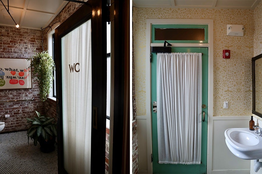 Two side-by-side photos show a rustic-chic restaurant bathrrom with distressed brick wall, greenery, and a patterned pale yellow wallpaper. A white curtain covers the mint-green-framed door.