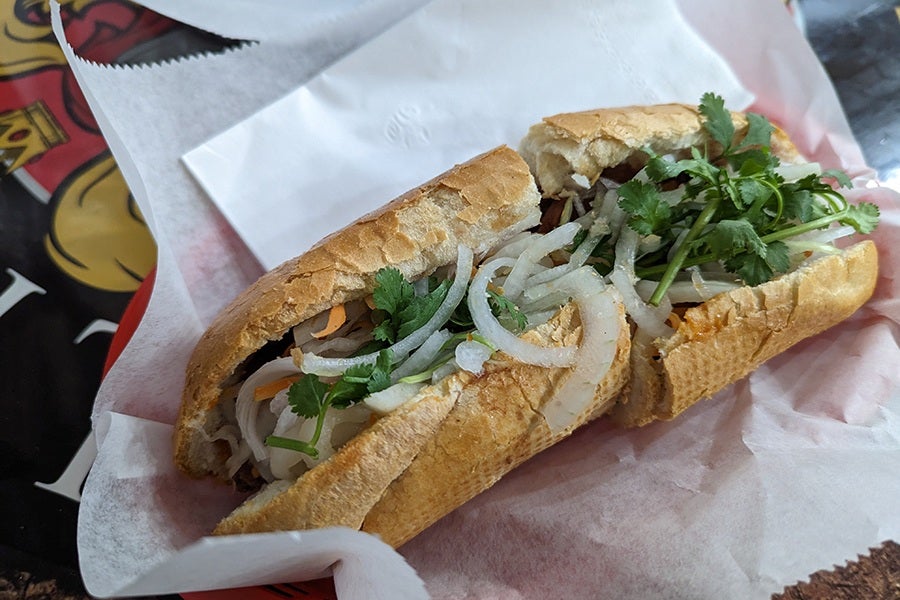 A Vietnamese-style sandwich sits on white paper.