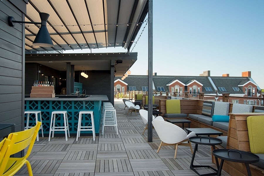 An empty rooftop bar is photographed during the day.