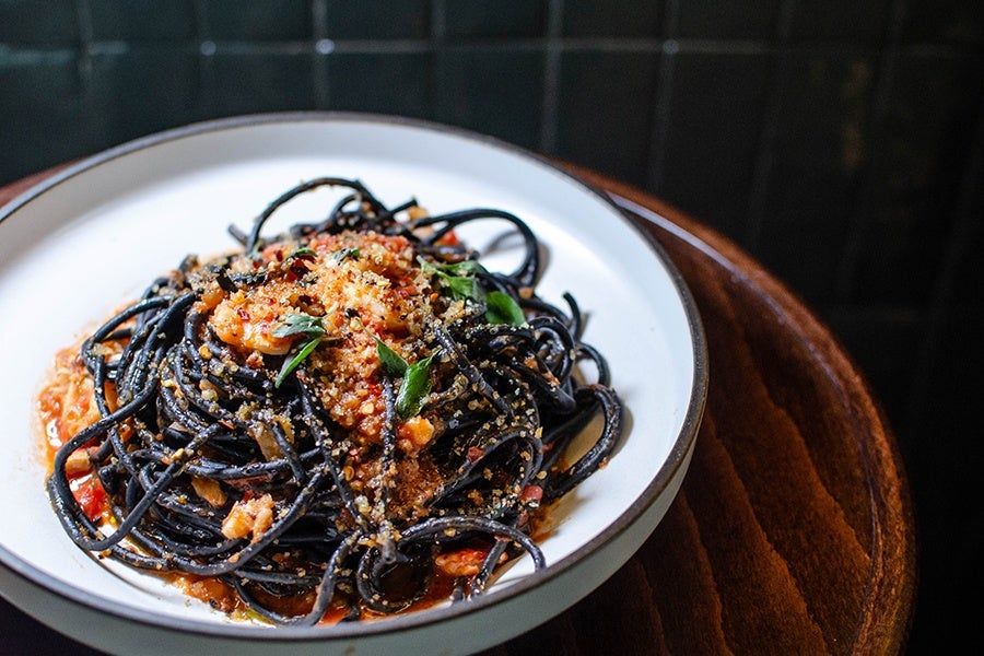 Black spaghetti is topped with lobster and breadcrumbs.