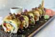 A sushi roll with lots of toppings.