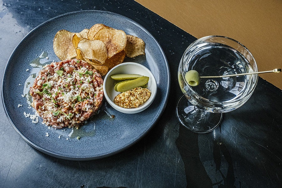 Steak tartare with potato chips, mustard, pickles, and a martini.