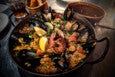 A pan is filled with shellfish and rice.