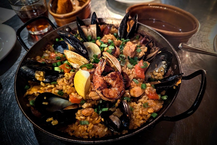 A pan is filled with shellfish and rice.
