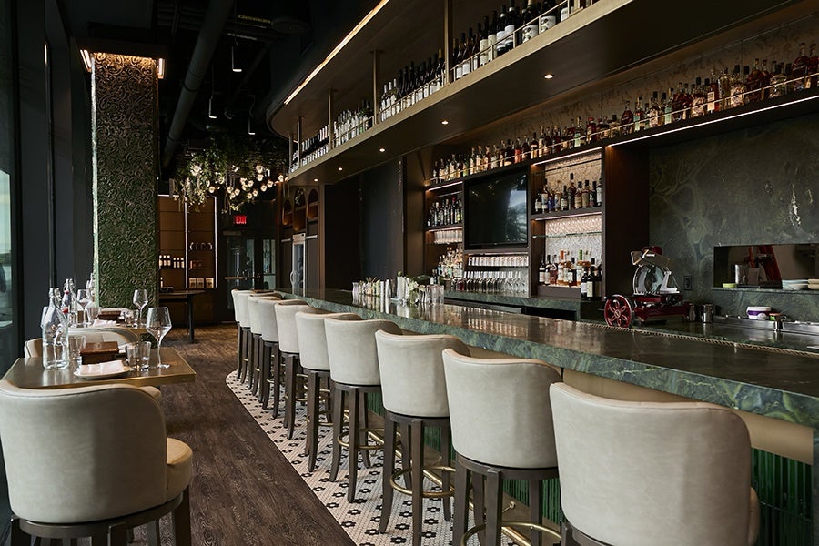 An interior restaurant photo includes a dark green marble bar and upscale-looking lounge seating.