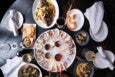 Overhead view of a table full of seafood, with a platter of oysters on the half shell in the center.