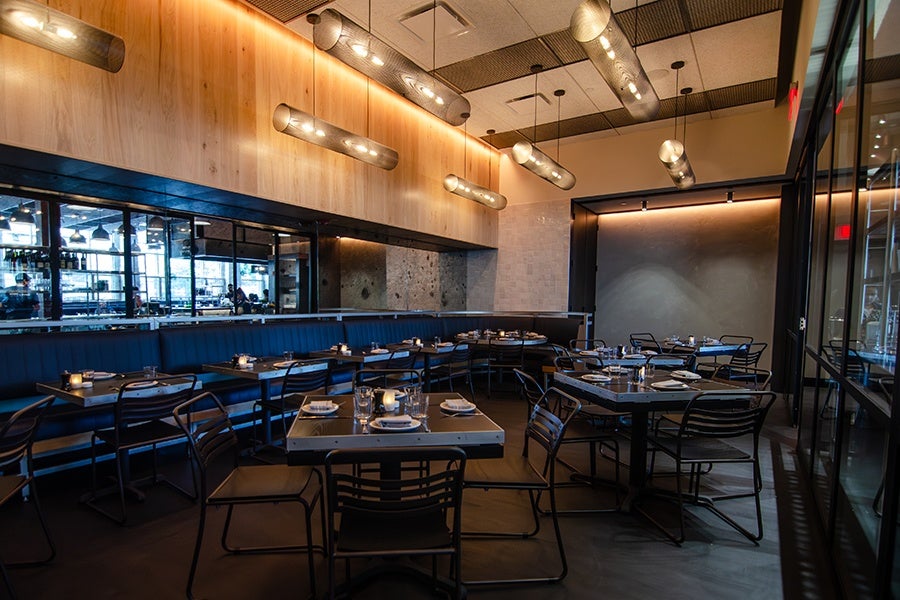 A dining room of a restaurant features deep blue banquettes.