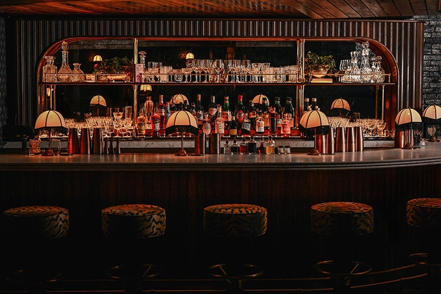 Interior photo of a dimly lit, speakeasy-style bar with Art Deco details.