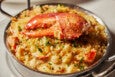 Creamy mac and cheese topped with breadcrumbs, herbs, and a lobster claw.
