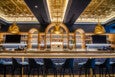 A bar area of a restaurant, empty of patrons, with dark blue, gold, and light wooden decor.