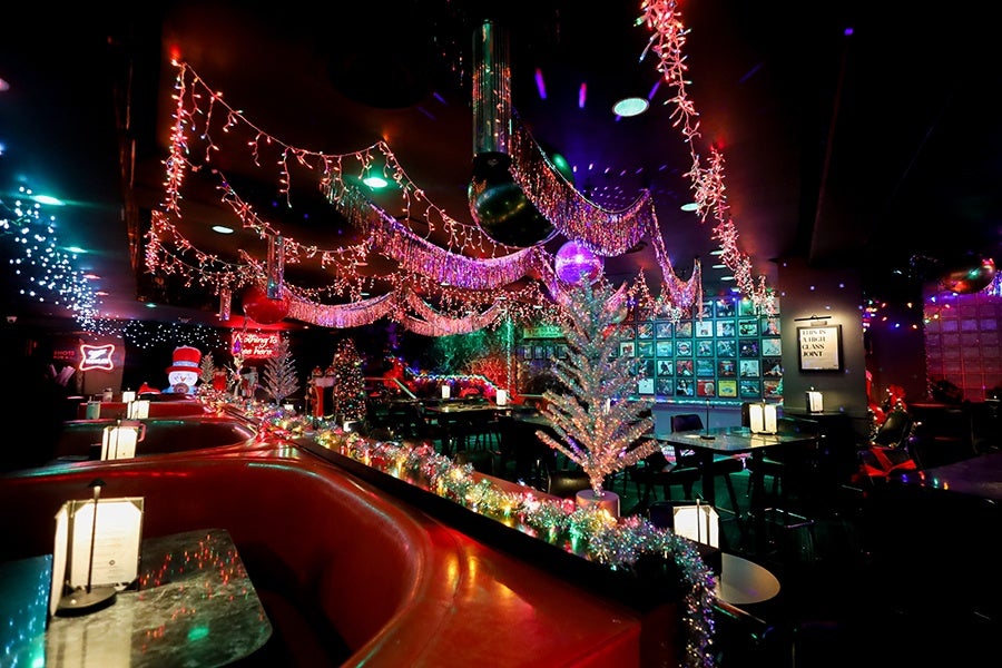 A bar is decorated with Christmas lights and other holiday decor.