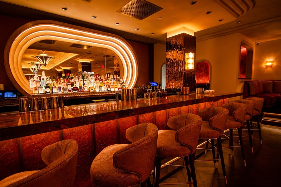 An upscale bar with lots of curved lines, reds, and golds.
