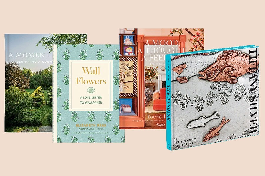 Four books are displayed side by side. From left to right: The first book has a cover featuring a lush green garden with the title "A MOMENT" partially visible. The second book, titled "Wall Flowers: A Love Letter to Wallpaper" by Elizabeth Rees, has a light blue cover with a green floral pattern. The third book shows an interior scene with shelves and a red chair, titled "A MOOD, A THOUGHT, A FEELING." The fourth book, titled "TITAN SILVER," has a cover featuring an artistic depiction of fish and aquatic plants in shades of copper and silver on a textured background.
