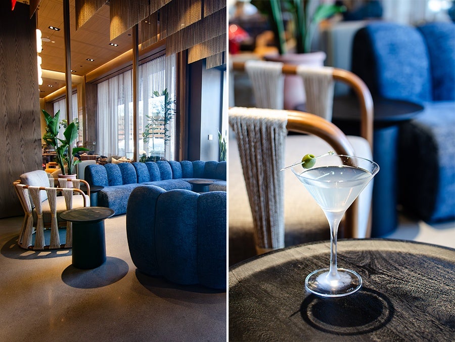 Modern lounge area with blue upholstered sofas and wooden armchairs featuring rope detailing, accompanied by small round black tables. A close-up shows a martini glass with a clear cocktail garnished with a green olive on one of the tables.