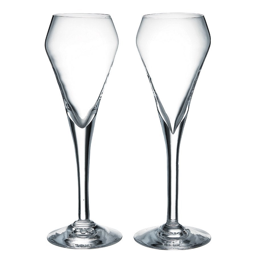 Two clear, uniquely shaped champagne flutes with a wide, angular bowl tapering sharply into the stem, each standing on a round base.
