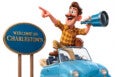 A cheerful cartoon man with a mustache, wearing a yellow plaid shirt and brown shoes, stands with one foot on the seat of a blue convertible car. He holds a blue telescope in one hand and points forward with the other. Next to him is a blue oval sign with gold trim that reads "WELCOME TO CHARLESTOWN.